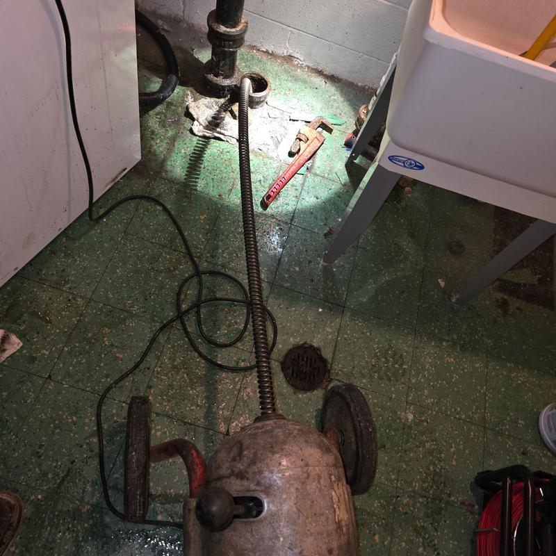 Sewer cable machine clearing basement drain blockage