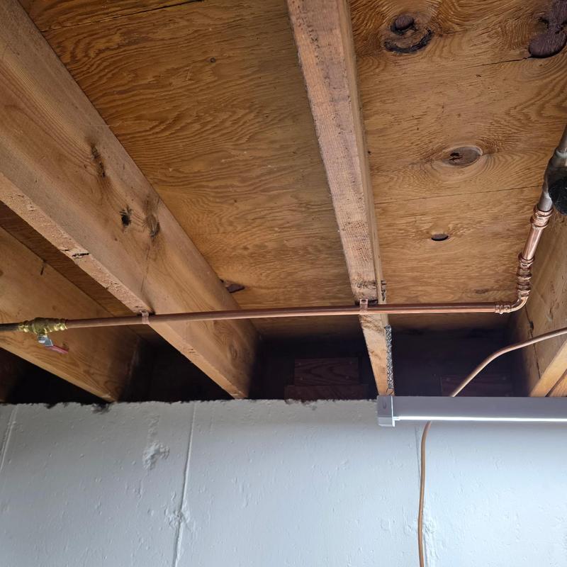 Copper water pipe installation under wooden ceiling joists