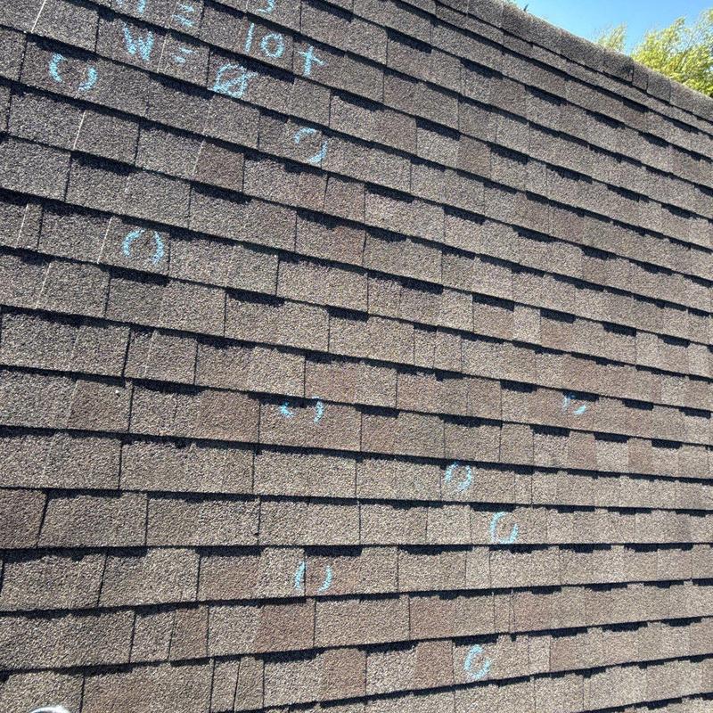 Asphalt shingle roof with marked hail damage spots