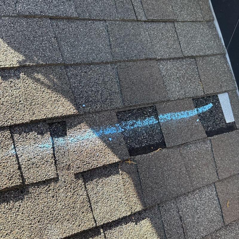 Roof shingles with hail damage marked for repair