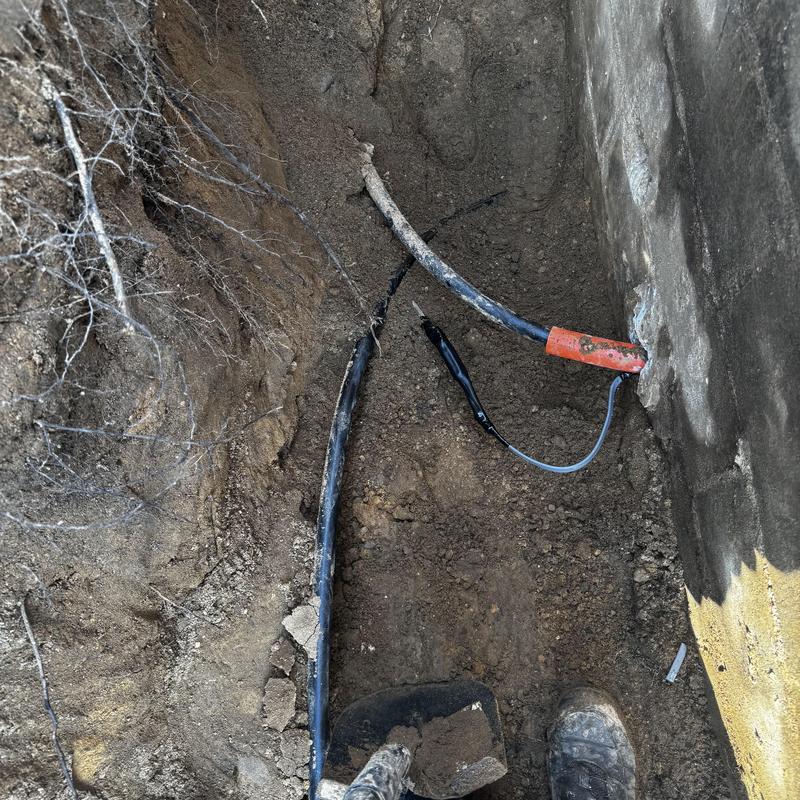 Well water line with electrical cable in trench