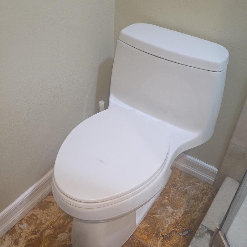 Toilet installation in bathroom corner on tile floor
