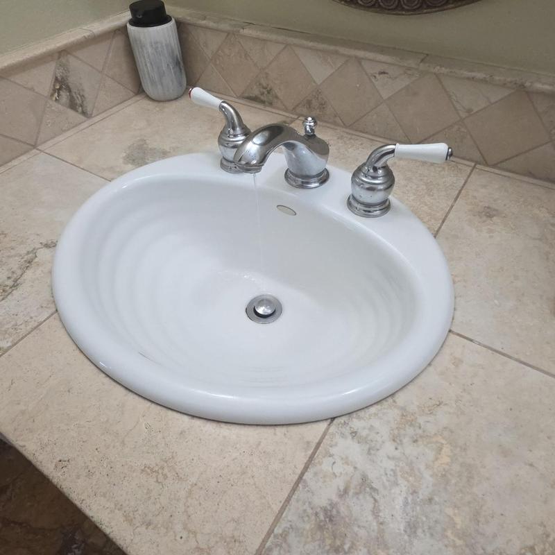 Bathroom sink faucet with water dripping