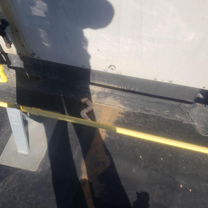 EPDM flat roof with damaged seam near solar panels EPDM flat roof with damaged seam near solar panels