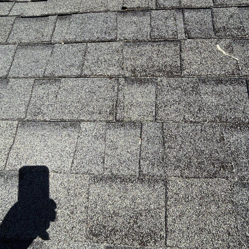 Asphalt shingles with hail damage on roof surface