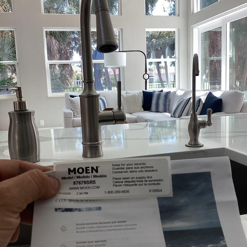 Moen kitchen faucet with label and living room view