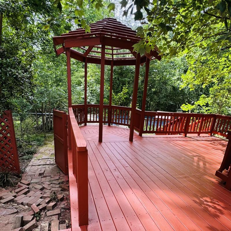 Wood deck with gazebo and railing in wooded yard Wood deck with gazebo and railing in wooded yard