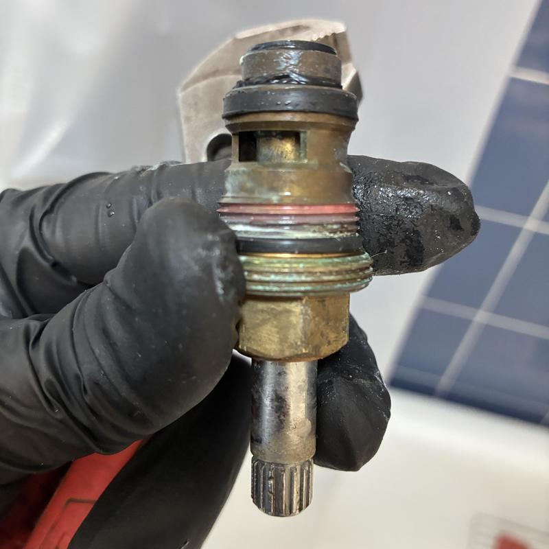 Shower faucet diverter valve held in gloved hand