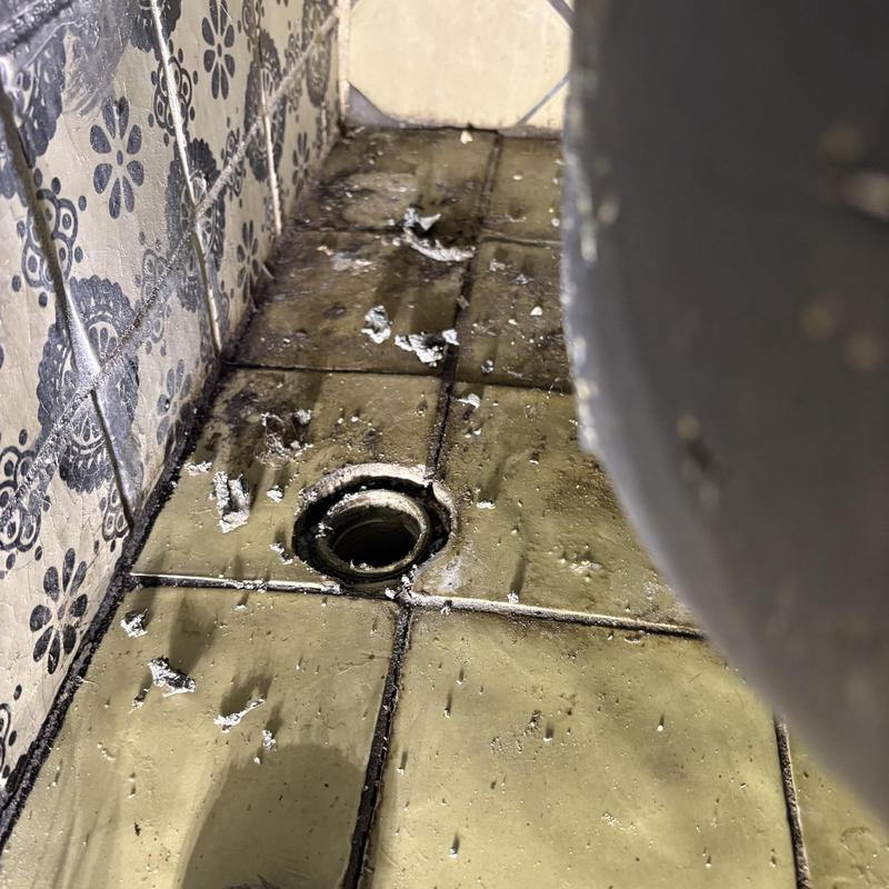 Tub drain hole with old grout and debris removal