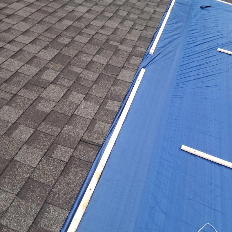 Roof tarp secured over damaged shingles for temporary fix Roof tarp secured over damaged shingles for temporary fix