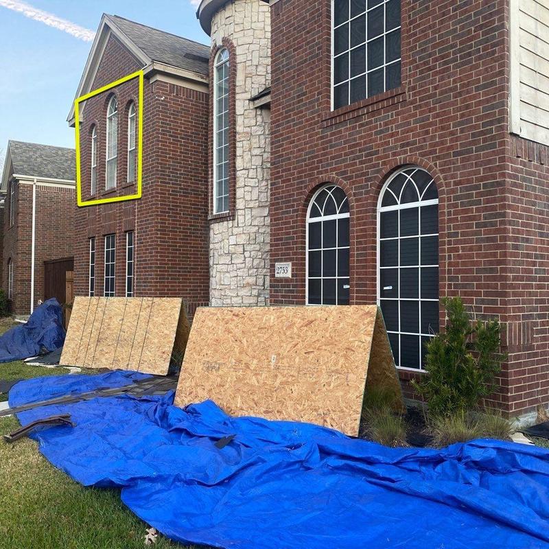 Arched windows with yellow outline on brick house exterior