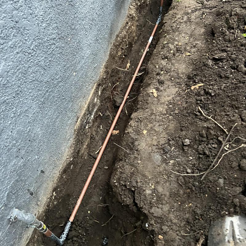 Copper gas line trench repair along building foundation