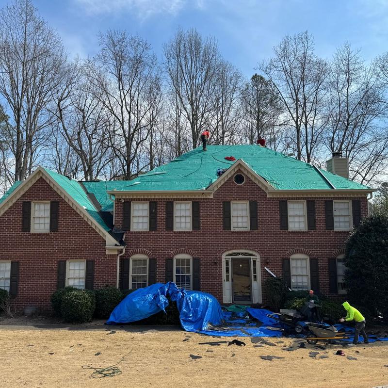 Asphalt shingle roof with protective tarp installation Asphalt shingle roof with protective tarp installation