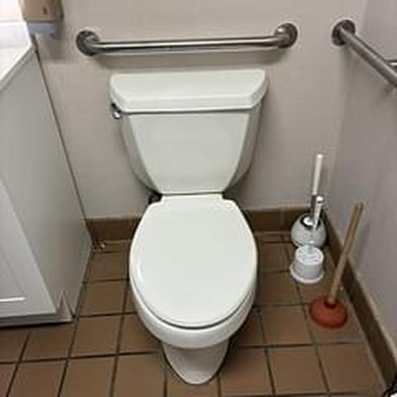 Toilet with grab bars in restroom corner