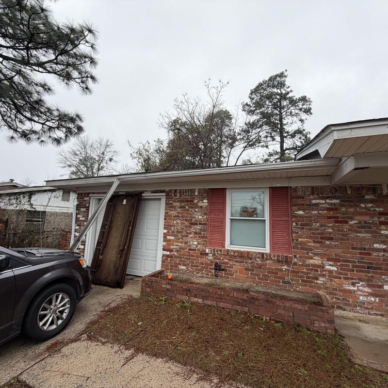 White 5-inch gutter and 2x3 downspout damage front corner