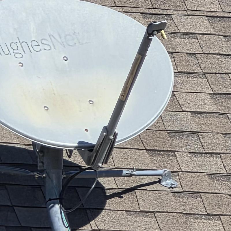 Satellite dish with hail damage on roof shingles