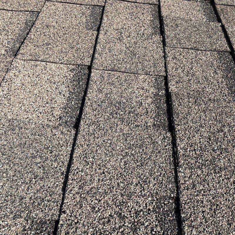 Asphalt shingle roof with hail damage close-up