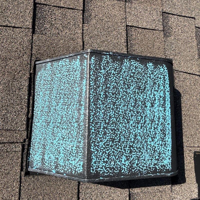Roof vent with hail damage on shingle roof surface