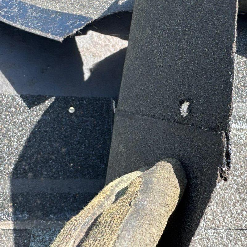 Asphalt shingle with hail damage and nail hole gap