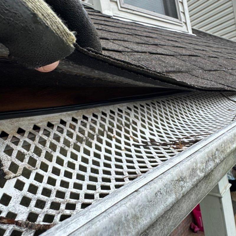Asphalt shingle roof edge with metal gutter guard inspection
