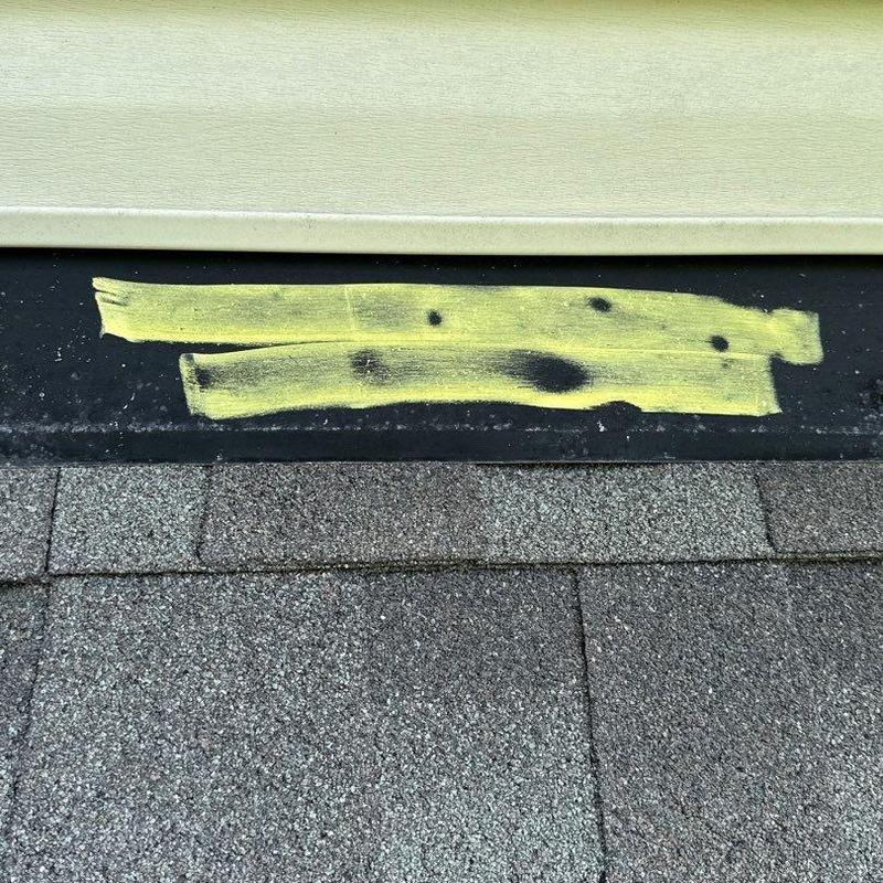 Roof flashing with hail damage marked for inspection