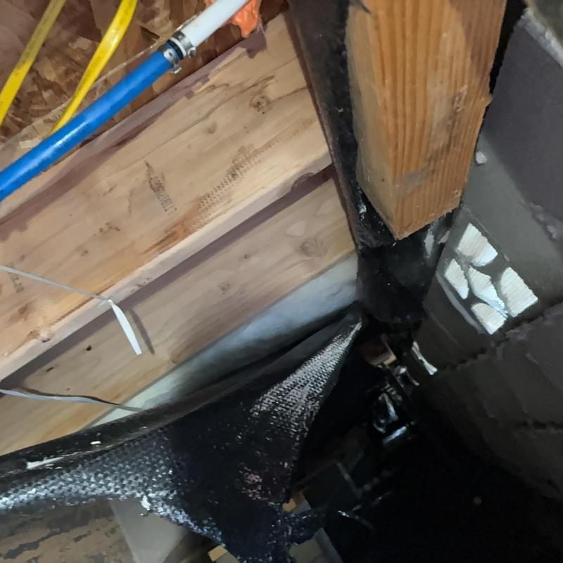 Pex water pipe section with clamps in crawl space