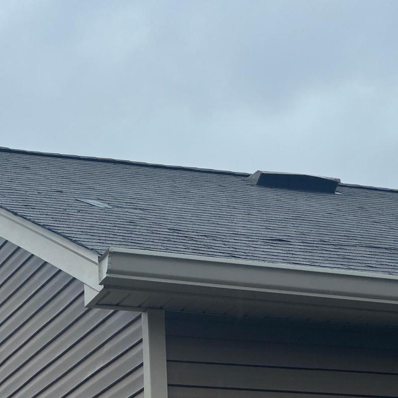 Roof shingles with visible damage on a residential house Roof shingles with visible damage on a residential house