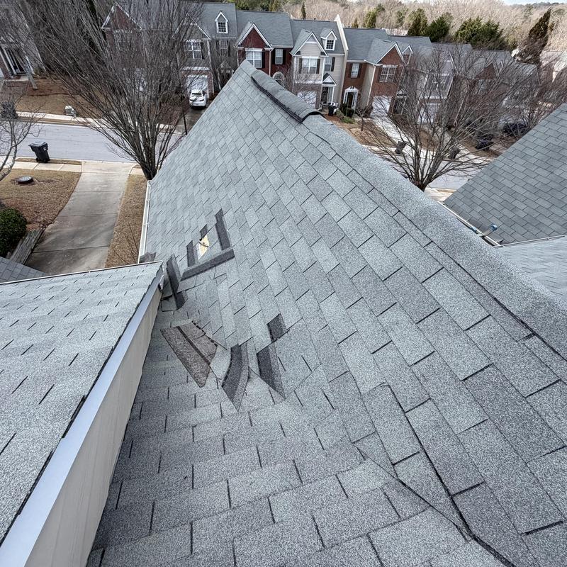 Missing shingles on Williamsburg grey roof valley with tarp