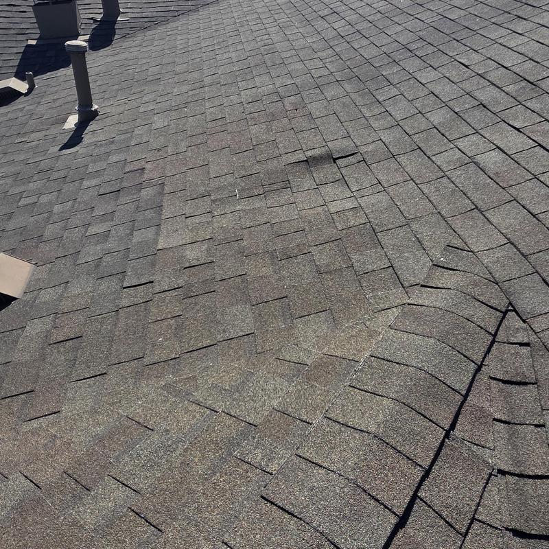 Asphalt shingle roof with visible hail damage and dent marks