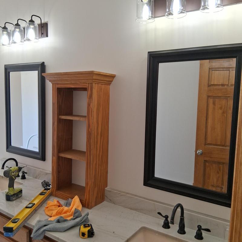 Bathroom mirrors and light fixtures with wooden shelving installation