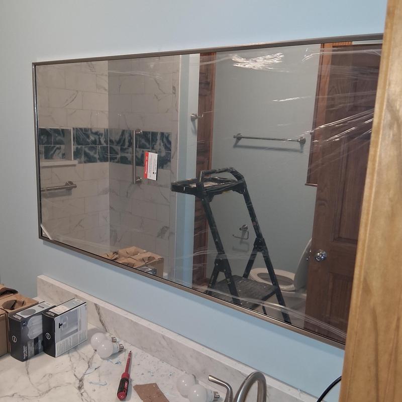 Bathroom mirror with protective film and new light bulbs