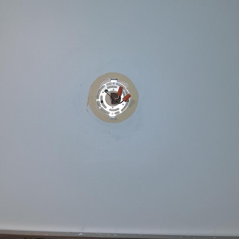 Light fixture mounting bracket with patched paint surrounding
