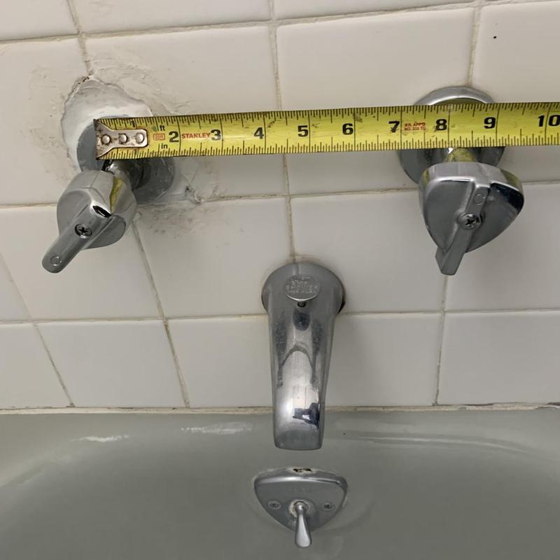 Shower valve with measuring tape on tile wall