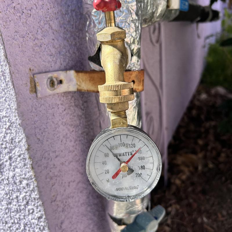 Water pressure gauge on outdoor brass valve