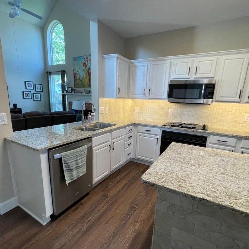 Quartz countertops and white cabinets with tile backsplash