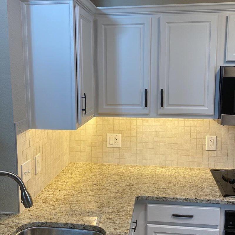 Quartz countertops with tile backsplash and painted cabinets