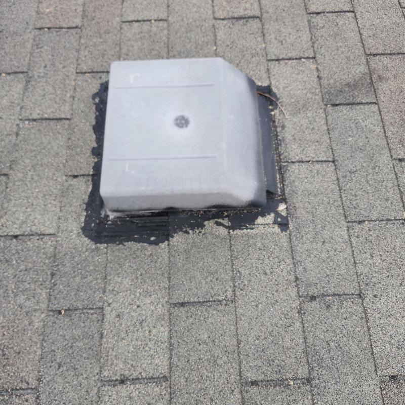 Roof vent with black sealant on asphalt shingles