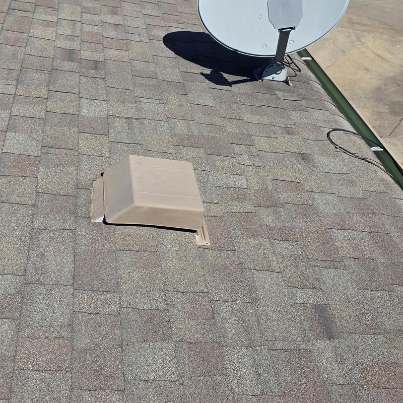 Roof shingles with wind and hail storm damage near vent.