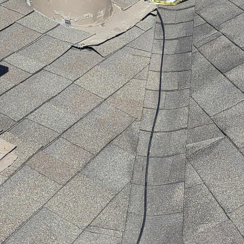 Asphalt shingle roof with vent pipe flashing damage