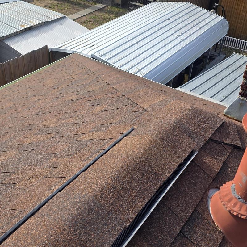 Asphalt shingle roof with ridge vent and nearby metal carports