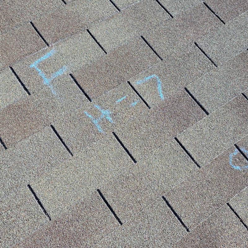 Asphalt shingle roof with hail damage markings