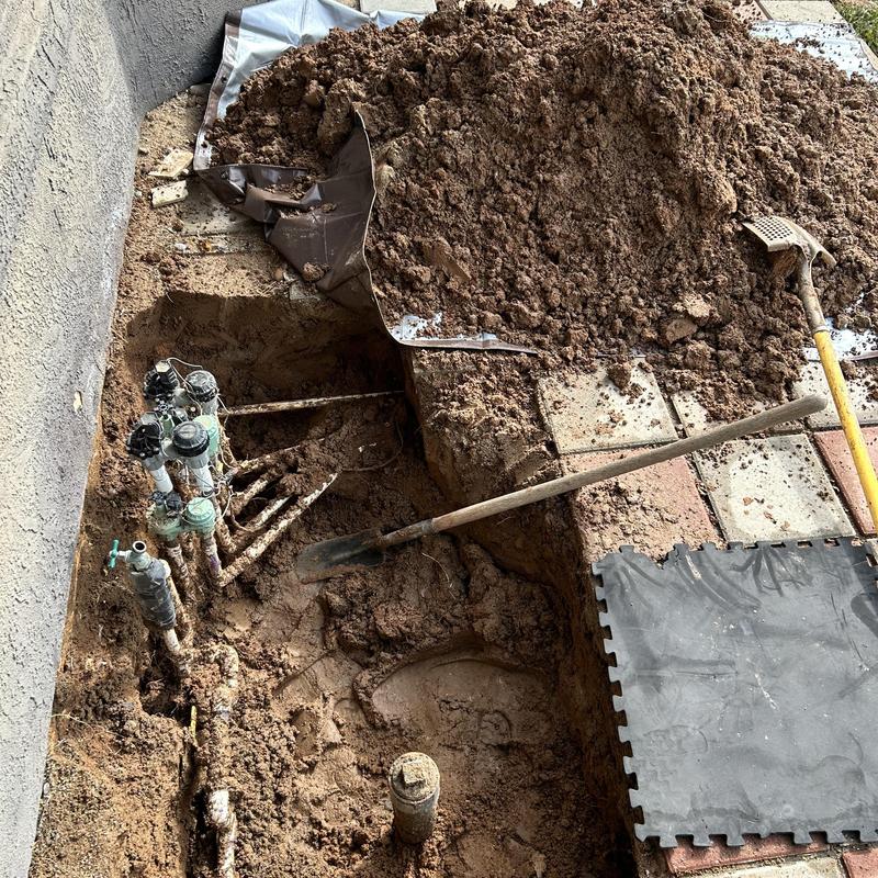 Irrigation valves and PVC piping exposed for repair