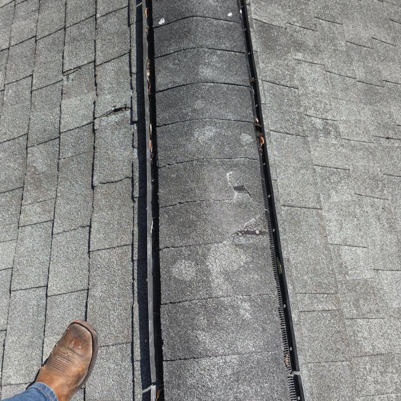 Ridge cap shingles with wind damage and granule loss