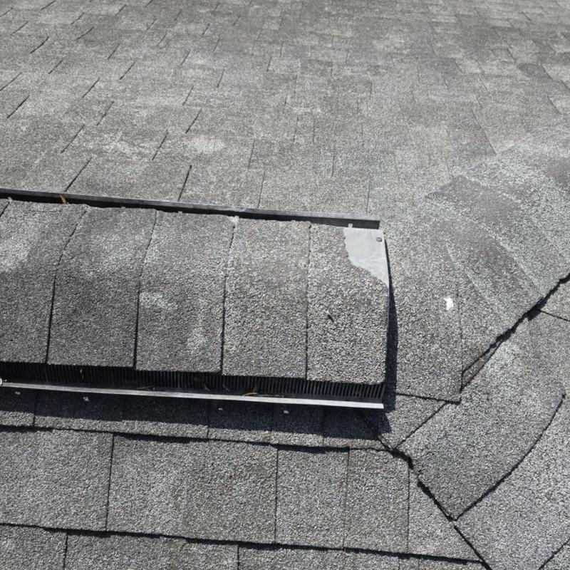 Asphalt ridge shingles with lifted and creased damage