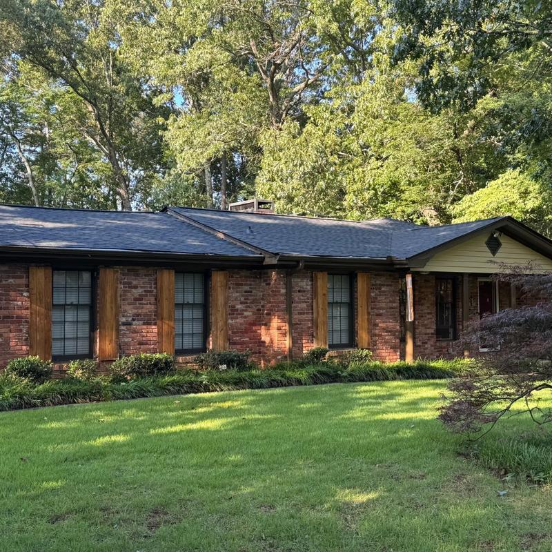 Asphalt shingle roof with repaired leaks on brick house