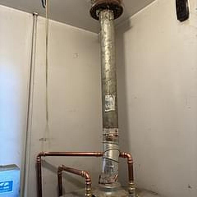 Copper water lines above water heater with ventilation pipe