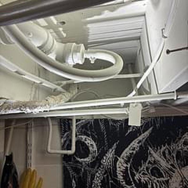 Kitchen drain pipe with added support straps in basement