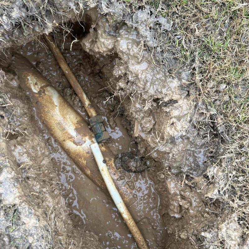 Water line pipe exposed in muddy ground excavation Water line pipe exposed in muddy ground excavation