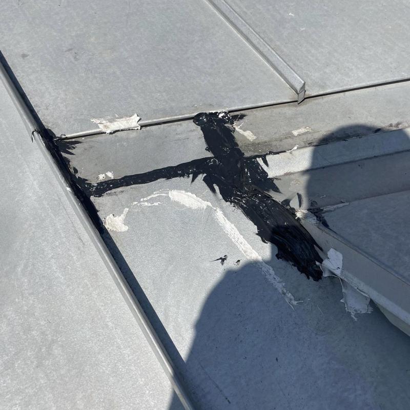 Standing seam metal roof seam with sealant patch