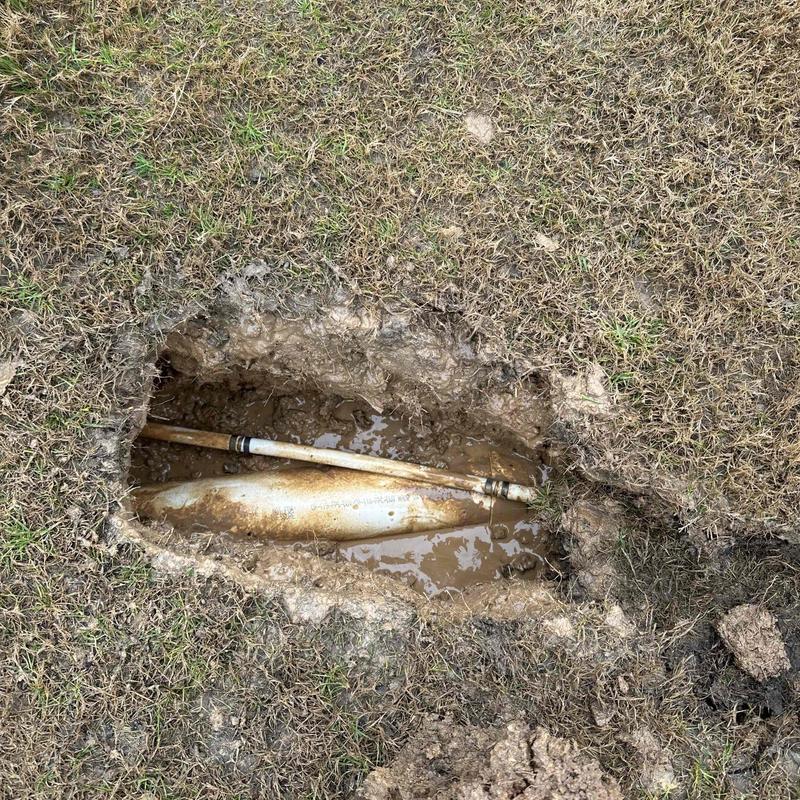 Water line exposed in muddy excavation for repair Water line exposed in muddy excavation for repair